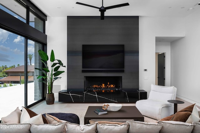 living room featuring a large fireplace and ceiling fan