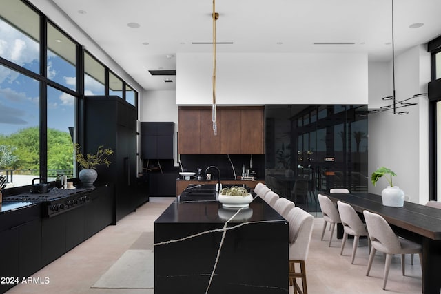 kitchen featuring tasteful backsplash, a sink, a center island with sink, and modern cabinets