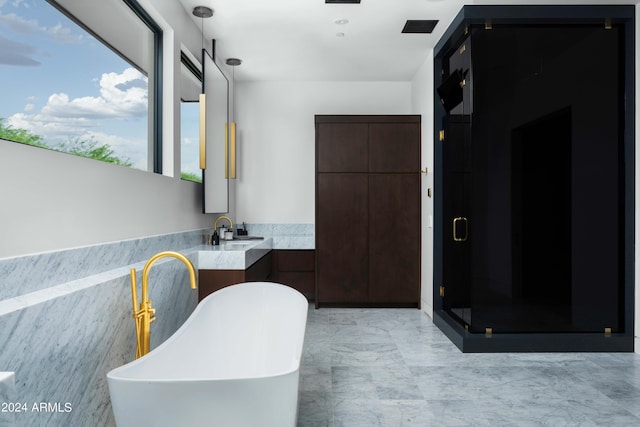 bathroom featuring a stall shower, a soaking tub, vanity, and visible vents
