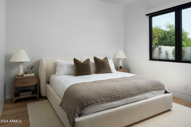 bedroom featuring baseboards and wood finished floors