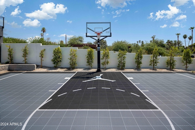 view of sport court featuring basketball hoop and fence