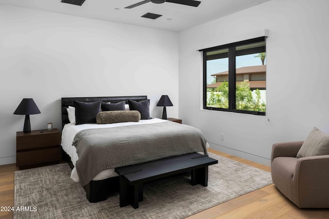 bedroom featuring wood finished floors, ceiling fan, baseboards, and visible vents
