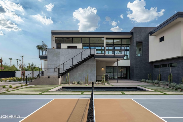 view of tennis court featuring stairs