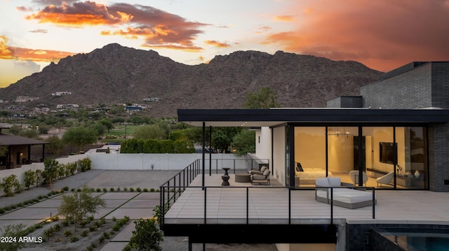 back of property at dusk featuring a patio area and a mountain view