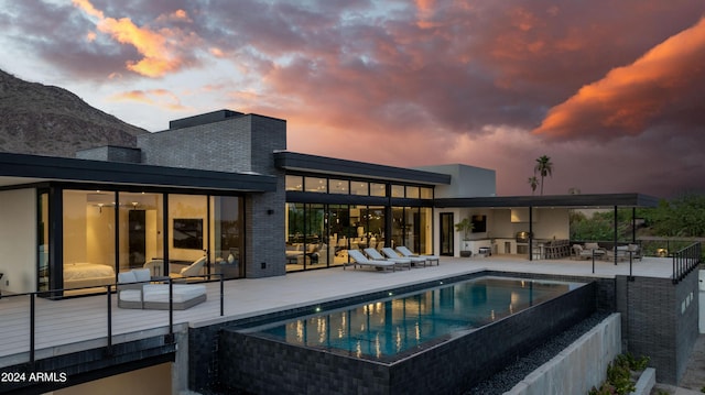 view of pool featuring an infinity pool, a patio, and a mountain view