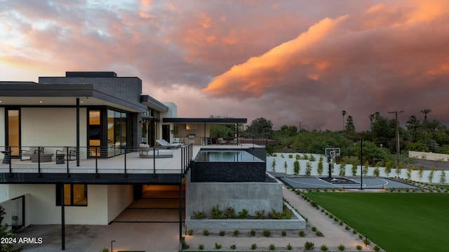 back of house featuring a patio, a fenced in pool, community basketball court, and a lawn