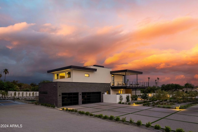 modern home featuring an attached garage, driveway, and stucco siding