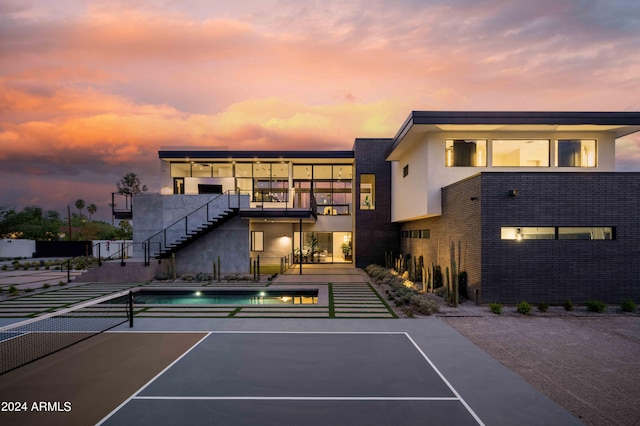view of tennis court featuring stairway