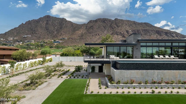 rear view of property with fence, a patio area, and a mountain view