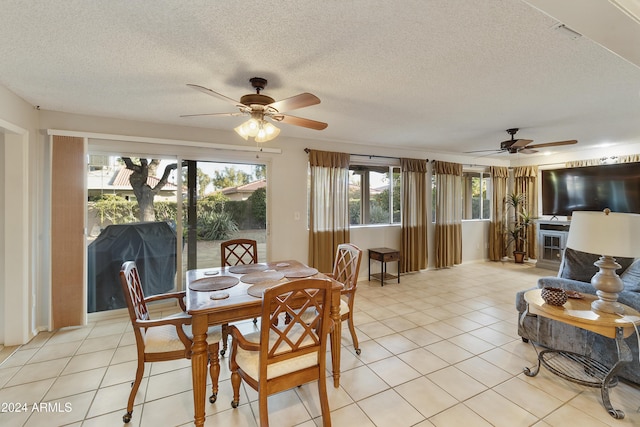 tiled dining room with ceiling fan and a textured ceiling