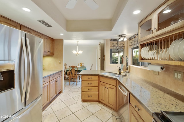 kitchen featuring decorative backsplash, light tile patterned floors, appliances with stainless steel finishes, a tray ceiling, and decorative light fixtures