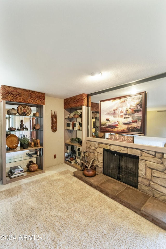 carpeted living room featuring a stone fireplace