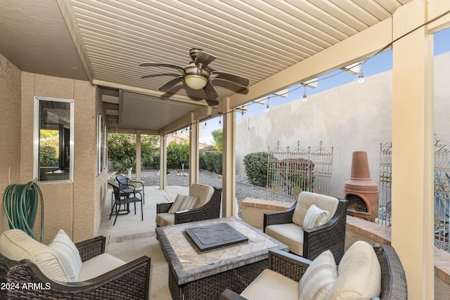 view of patio / terrace with an outdoor living space with a fireplace and ceiling fan