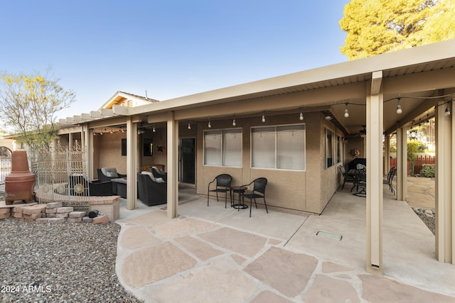 back of house with an outdoor living space, ceiling fan, and a patio