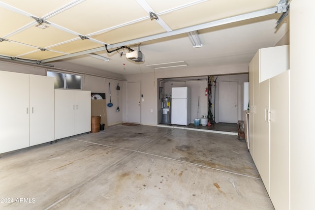 garage featuring white refrigerator and a garage door opener