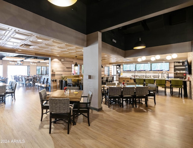 dining area with wood-type flooring and a high ceiling