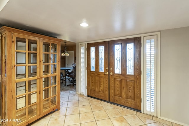 tiled entrance foyer with french doors and an inviting chandelier