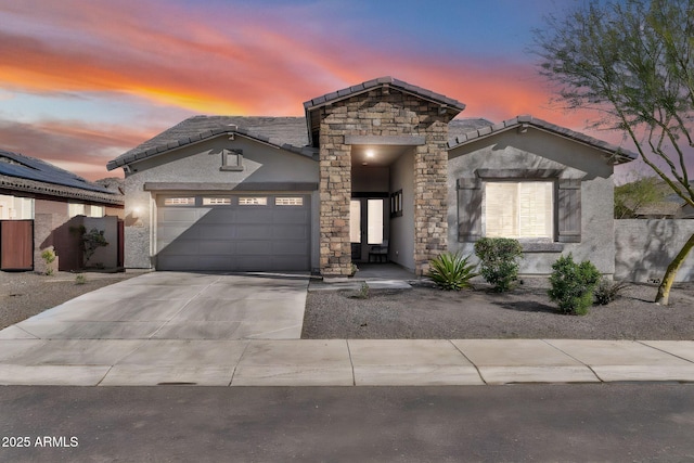 view of front facade featuring a garage, concrete driveway, stone siding, and stucco siding