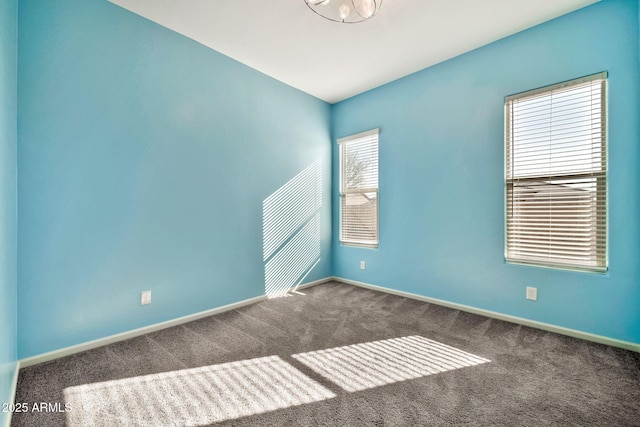 empty room with baseboards and dark carpet