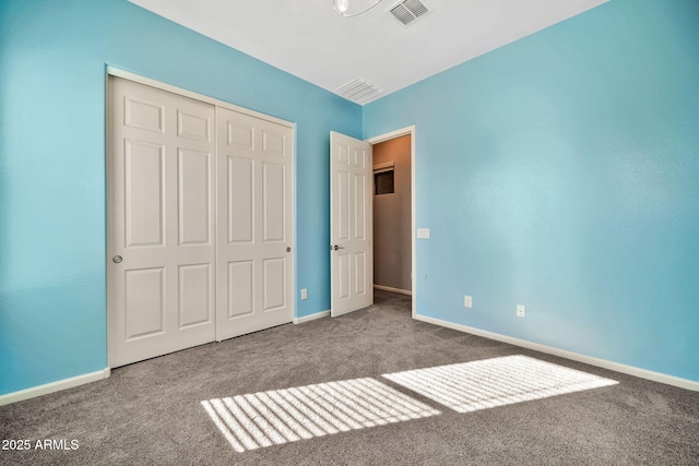 unfurnished bedroom with baseboards, carpet, visible vents, and a closet