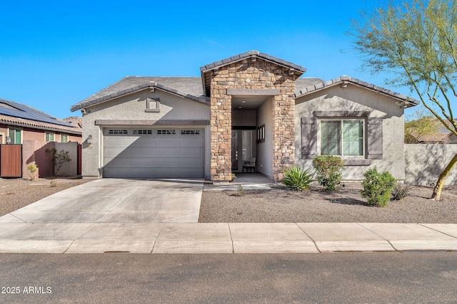 view of front facade featuring concrete driveway, stone siding, an attached garage, fence, and stucco siding