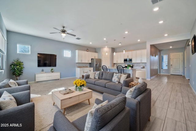 living area featuring baseboards, ceiling fan, visible vents, and recessed lighting