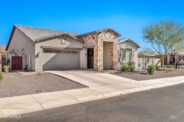 view of front of house featuring driveway, stone siding, an attached garage, fence, and stucco siding