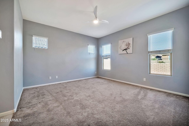 spare room with light carpet, ceiling fan, and baseboards