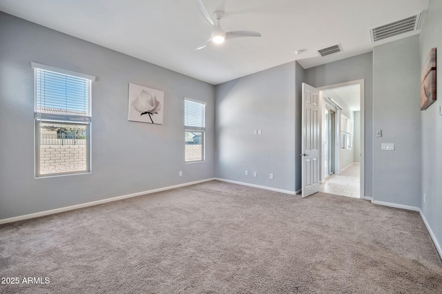 unfurnished room with baseboards, visible vents, a ceiling fan, and light colored carpet