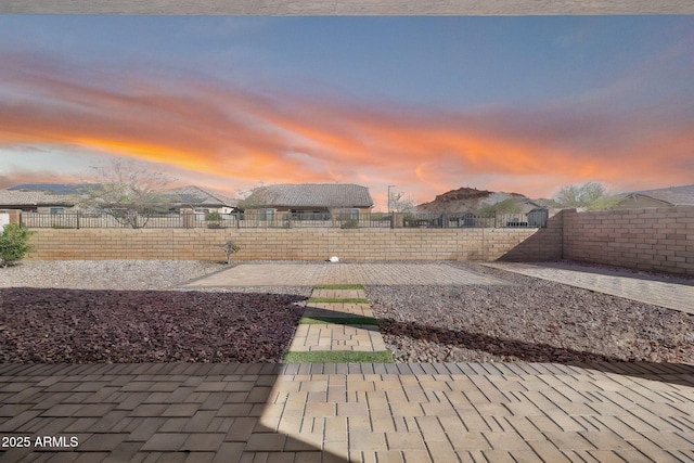 yard at dusk featuring a patio and a fenced backyard