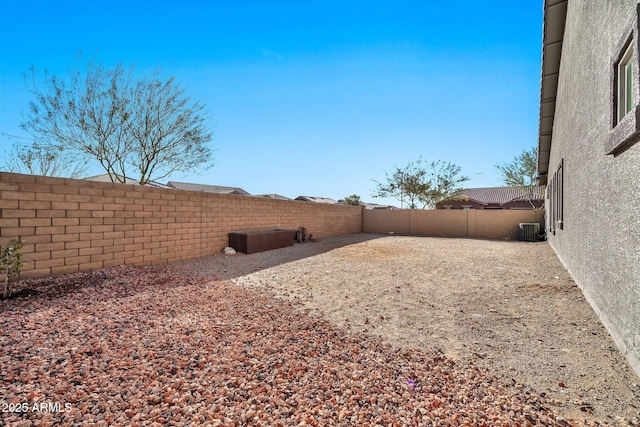 view of yard featuring a fenced backyard and central air condition unit