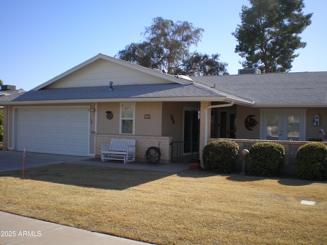 single story home featuring brick siding, a shingled roof, a garage, driveway, and a front lawn