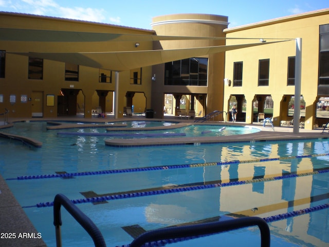 view of swimming pool featuring a hot tub and a patio area