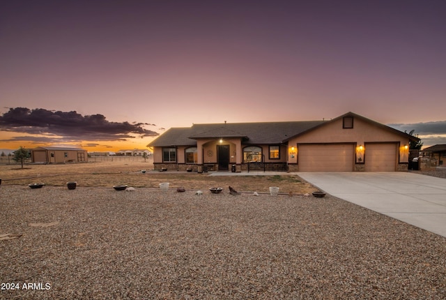 view of front of house with stucco siding, stone siding, concrete driveway, and an attached garage