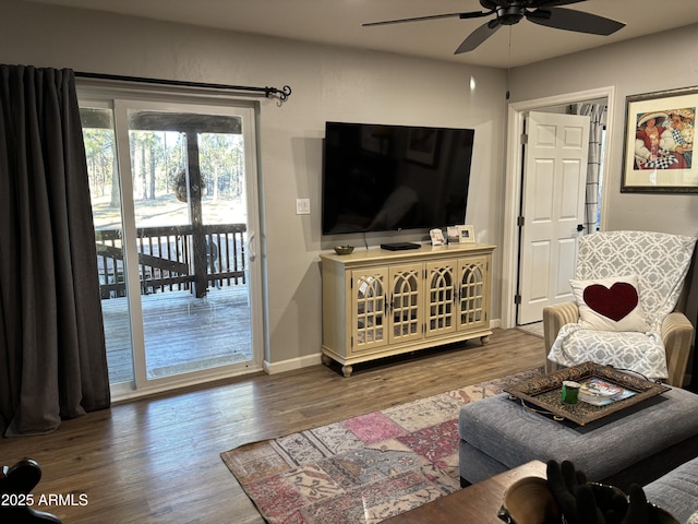 living room with baseboards, a ceiling fan, and wood finished floors