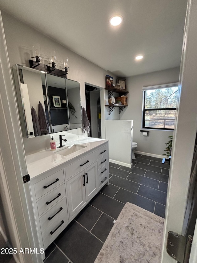 bathroom featuring toilet, recessed lighting, vanity, baseboards, and tile patterned floors