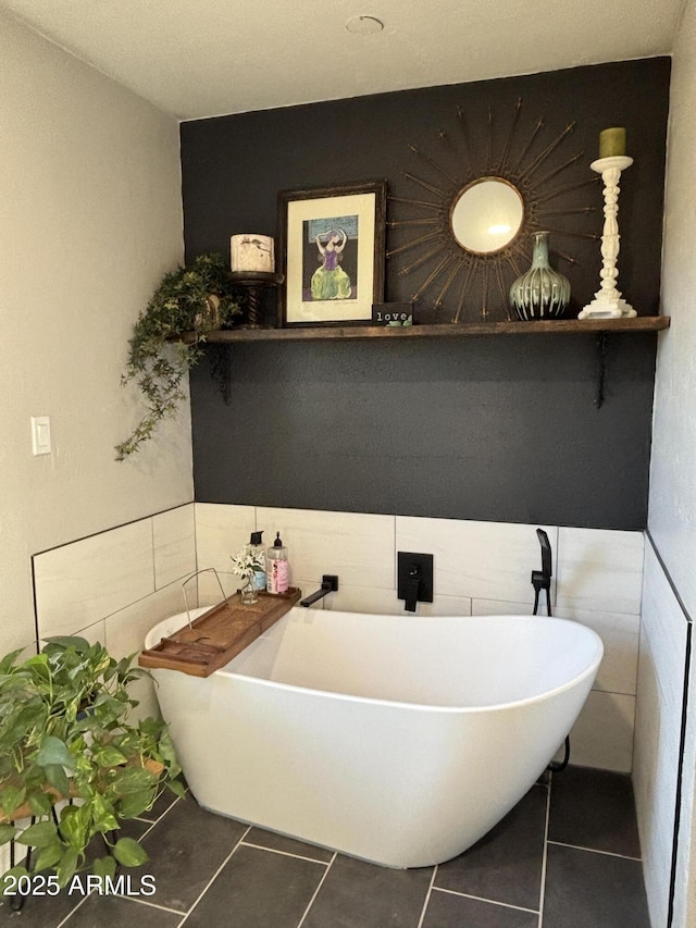 bathroom featuring a soaking tub, tile walls, and tile patterned floors