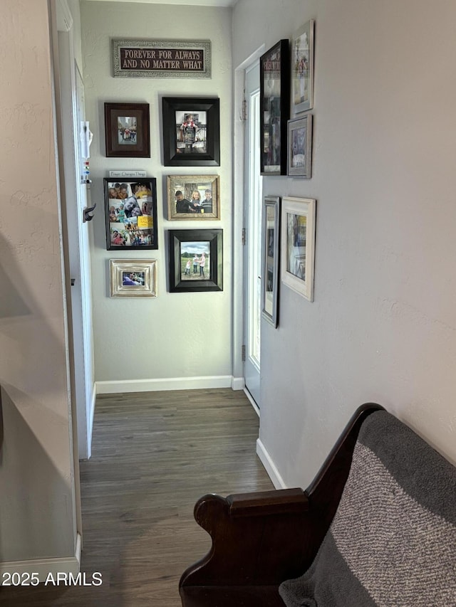 corridor with wood finished floors and baseboards