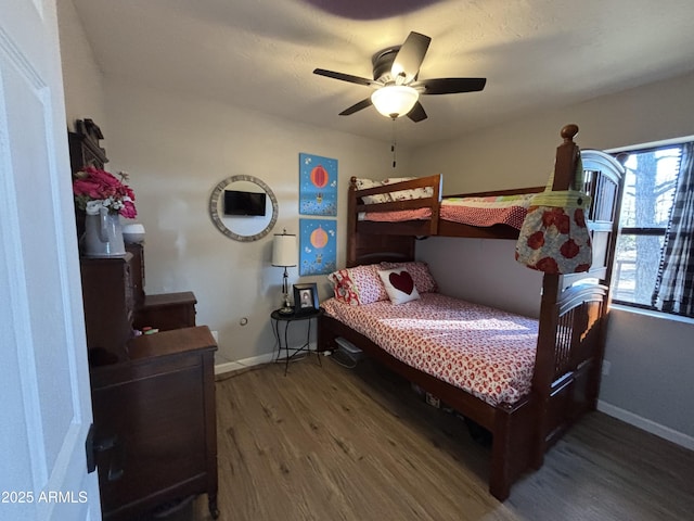 bedroom with a ceiling fan, baseboards, and wood finished floors