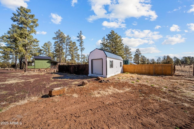 view of yard with a shed, fence, and an outdoor structure