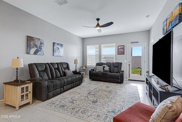 living room featuring light tile patterned floors, visible vents, and a ceiling fan
