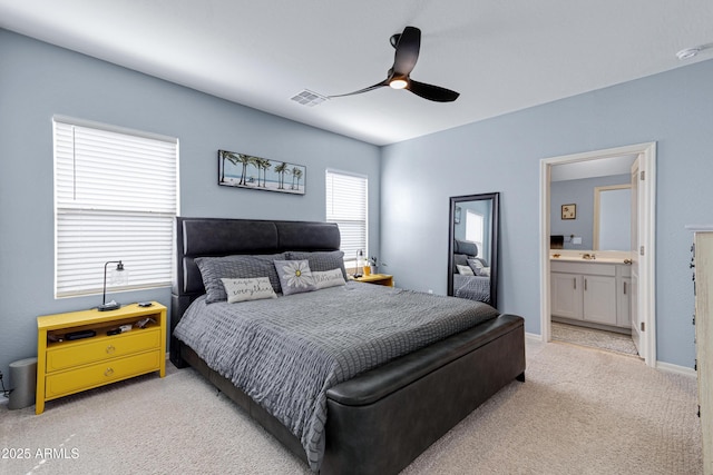 bedroom with ceiling fan, light carpet, a sink, visible vents, and baseboards