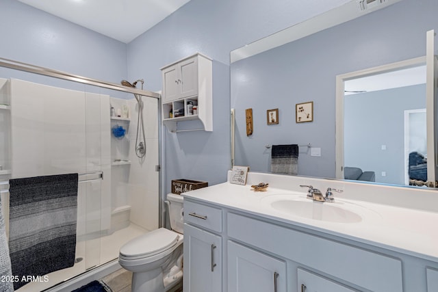 bathroom with vanity, a shower stall, toilet, and tile patterned floors