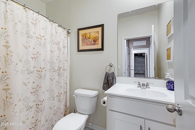 bathroom with curtained shower, a textured wall, vanity, and toilet
