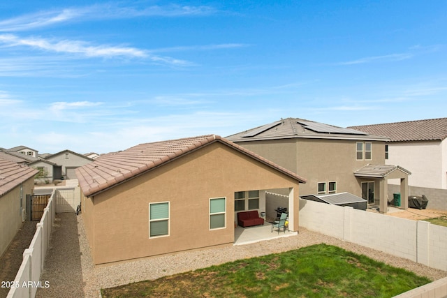 back of property featuring a fenced backyard, a tiled roof, a yard, stucco siding, and a patio area