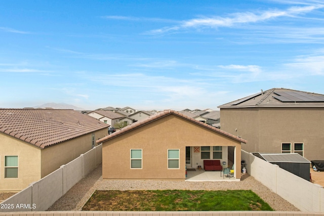 back of house with stucco siding, a fenced backyard, and a patio