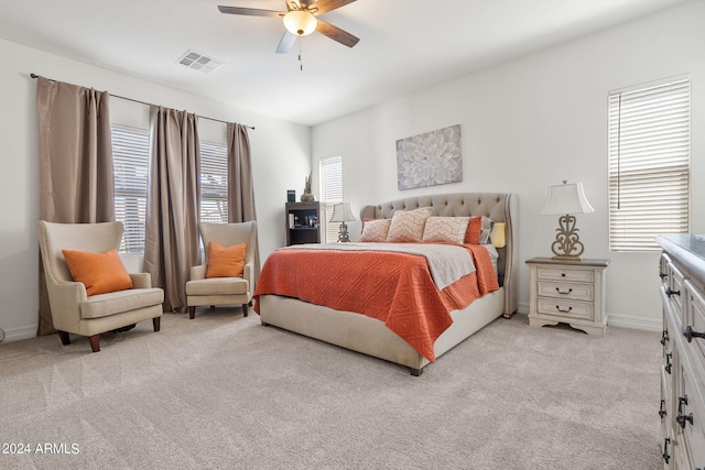 carpeted bedroom featuring ceiling fan and multiple windows