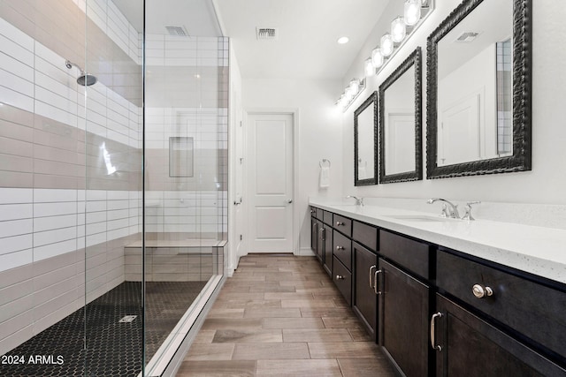 bathroom featuring an enclosed shower and double sink vanity