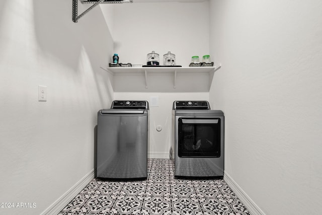 clothes washing area featuring washing machine and dryer and light tile flooring