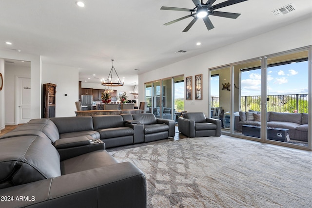 living room featuring ceiling fan with notable chandelier and light carpet